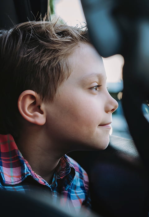 a student looks out the window of a bus